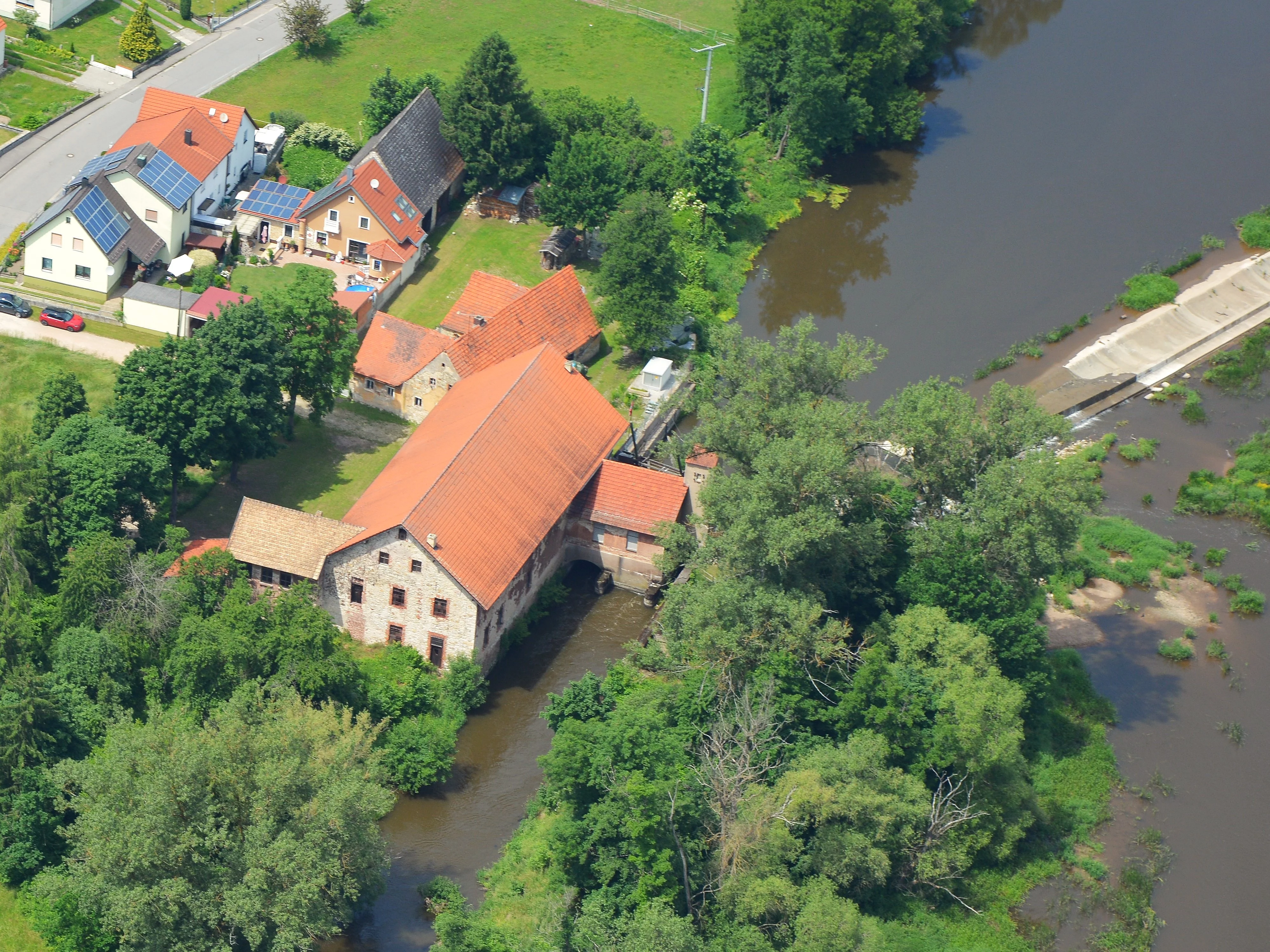 Ein sehr altes Gebäude am Ufer des Flusses Naab, auf direkter Höhe zum Wehr.