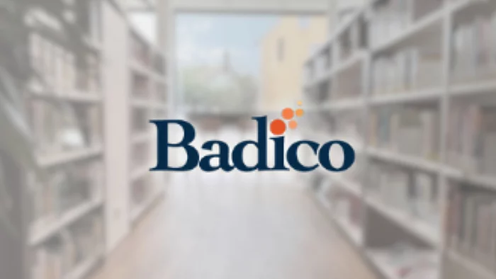 Unscharfer Bibliothekshintergrund mit Bücherregalen und Fensterfront. In der Bildmitte befindet sich das Logo „Badico“ in dunkelblauer Schrift, ergänzt durch mehrere orangefarbene Punkte oberhalb des Schriftzugs. Die Darstellung verweist auf ein digitales Angebot oder Portal der Stadtbücherei.