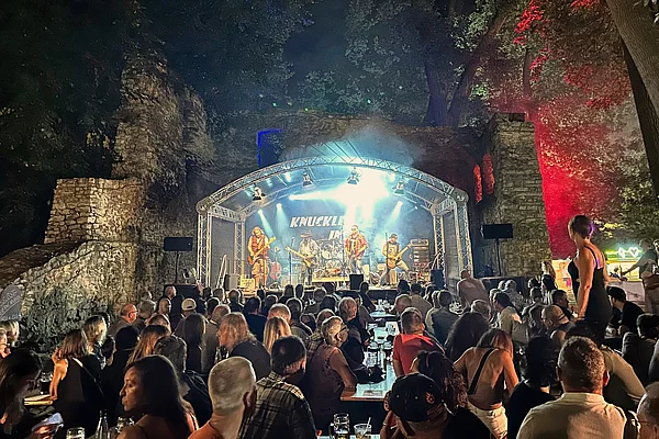 Gefüllter Festplatz in der Schlossruine während des Auftritts einer Rockband.