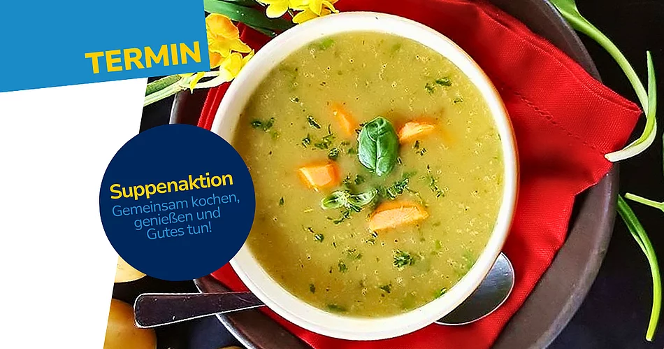 Eine weiße Schüssel mit cremiger Gemüsesuppe, garniert mit Karottenstückchen und frischen Kräutern. Die Schüssel steht auf einer roten Stoffserviette und einem dunklen Teller. Rundherum liegen Kartoffeln, grüne Blätter und gelbe Blüten auf einem schwarzen Untergrund.