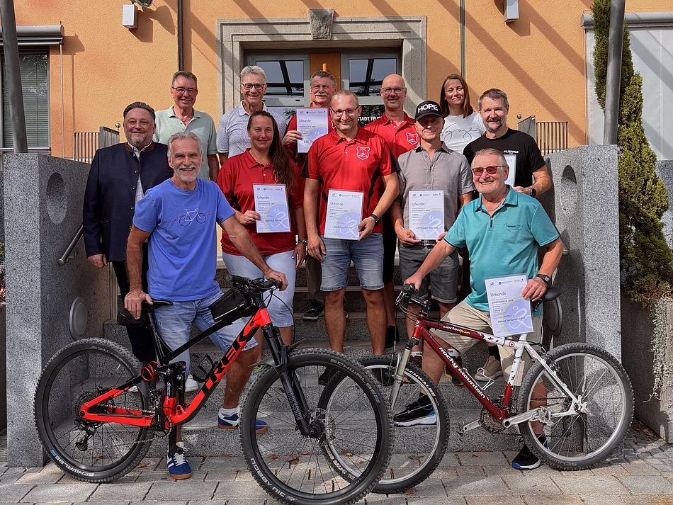 Eine Gruppe der ausgezeichneten Teilnehmerinnen und Teilnehmer des STADTRADELN 2026 steht mit Urkunden und Fahrrädern gemeinsam mit Bürgermeister Thomas Beer vor dem Teublitzer Rathaus.