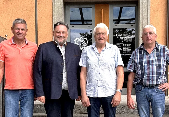 Geschäftsleiter Franz Härtl, Erster Bürgermeister Thomas Beer, der neu vereidigte Feldgeschworene Franz Reil und Obmann Klaus Obermeier stehen gemeinsam auf den Stufen vor dem Eingang des Teublitzer Rathauses.