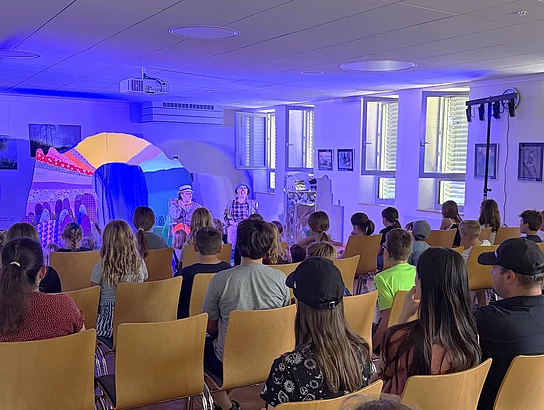 Kinder und Erwachsene verfolgen gemeinsam die Theateraufführung im Bürgersaal des Mehrgenerationenhauses.