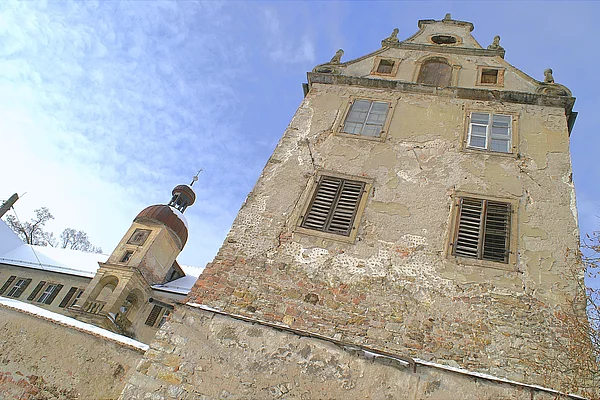 Uhrenturm und Seitenflügel aus schrägem Winkel im Winter.