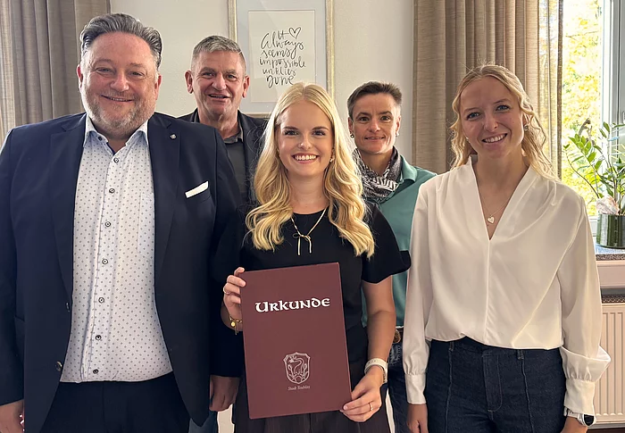 Gruppenfoto anlässlich des Ausbildungsabschlusses von Anna-Maria Schmid im Teublitzer Rathaus. Anna-Maria Schmid steht mit ihrer Abschlussurkunde in der Mitte. Um sie herum stehen Bürgermeister Thomas Beer, Geschäftsleiter Franz Härtl, Bauamtsleiterin Sabine Eichinger und die stellvertretende Personalratsvorsitzende Anna Beer. Alle fünf blicken lächelnd in die Kamera.