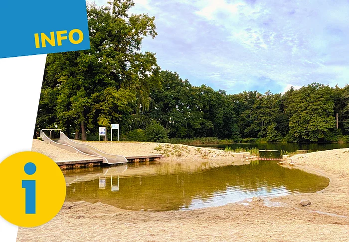 Blick auf den flachen Kinderbereich der Badestelle „Höllohe“ in Teublitz mit Sandstrand, Wasserrutsche und angrenzendem Weiher; die Grafik ist mit einem Info-Symbol versehen.
