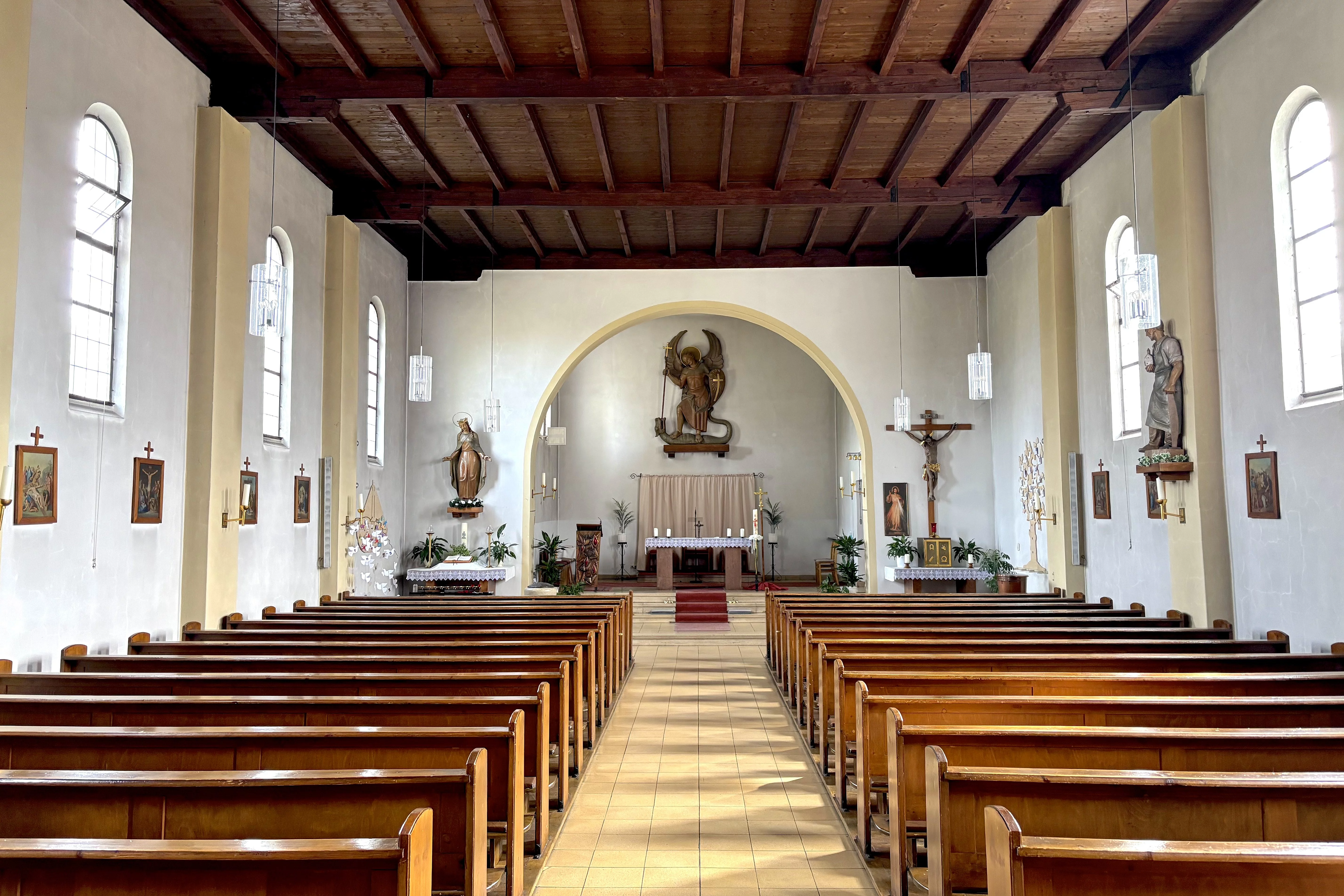 Imposanter hallenähnlicher Innenraum einer Kirche. In der Mitte des Bildes befindet sich der Altar.