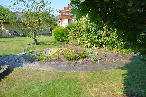 Ein angelegtes Beet in Form eines Schneckenhauses, das mit Kräutern bepflanzt ist.