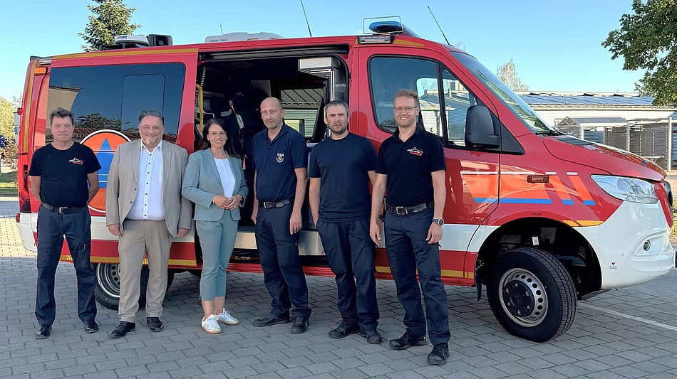 Sechs Personen stehen vor dem neuen roten CBRN-Erkundungswagen der Freiwilligen Feuerwehr Teublitz. Zu sehen sind Vertreter der Feuerwehr sowie Erster Bürgermeister Thomas Beer, die Parlamentarische Staatssekretärin Martina Englhardt-Kopf und Kreisbrandrat Christian Demleitner. Das Einsatzfahrzeug ist seitlich mit geöffneter Schiebetür abgebildet.