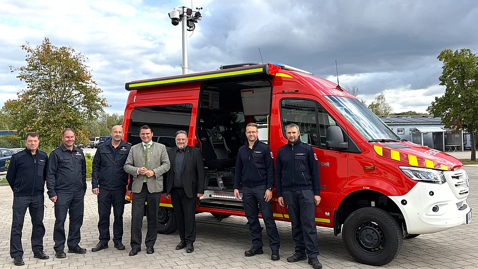 Sieben Personen aus Feuerwehr, Kreisbrandinspektion und Politik stehen für ein gemeinsames Foto vor dem geöffneten roten Einsatzleitwagen der Feuerwehr Teublitz.