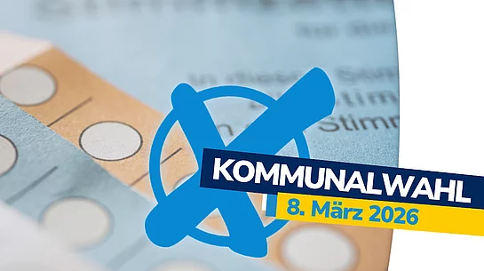 Das Bild zeigt einen grafisch gestalteten Hinweis zur Kommunalwahl. Im Hintergrund liegen unscharfe Wahlzettel mit markierbaren Kreisen. Im Vordergrund befindet sich ein großes blaues Wahlkreuz. Darüber liegt ein dunkelblauer Balken mit dem weißen Schriftzug „KOMMUNALWAHL“, ergänzt durch einen gelben Balken mit dem Datum „8. März 2026“.