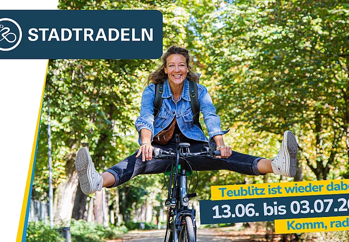 Eine lachende Frau fährt auf einem Fahrrad durch eine von Bäumen gesäumte Allee. Während der Fahrt streckt sie beide Beine seitlich aus und balanciert freihändig auf dem Fahrrad. Sie trägt eine Jeansjacke, Turnschuhe und einen kleinen Rucksack. Im Bild eingeblendet sind Hinweise zum STADTRADELN in Teublitz mit dem Zeitraum vom 13. Juni bis 3. Juli 2026 und der Aufforderung „Komm, radel mit!“.