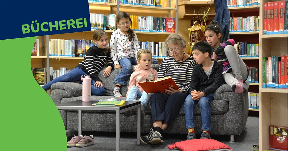 Ein Werbebild für die Stadtbücherei zeigt eine ältere Frau, die mehreren Kindern auf einem Sofa aus einem Buch vorliest. Die Kinder sitzen aufmerksam um sie herum und hören gespannt zu. Im Hintergrund sind Bücherregale der Bücherei zu sehen. Links oben steht gut sichtbar der Schriftzug „BÜCHEREI“.