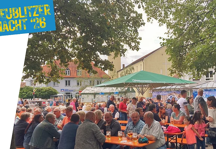 Grafik zur „Teublitzer Nacht ’26“ mit einer stimmungsvollen Aufnahme des Marktplatzes in Teublitz. Zahlreiche Besucherinnen und Besucher sitzen und stehen an Biertischen unter großen Bäumen und Sonnenschirmen, unterhalten sich und genießen den Abend. Im Hintergrund sind Marktstände und Gebäude rund um den Platz zu sehen. Oben links steht auf blauem Hintergrund der Schriftzug „Teublitzer Nacht ’26“.
