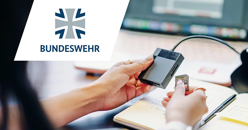 Symbolbild eines Datenträgerchips, der gerade in ein Lesegerät eingesteckt wird. Im Vordergrund ist das Logo der Bundeswehr zu sehen.