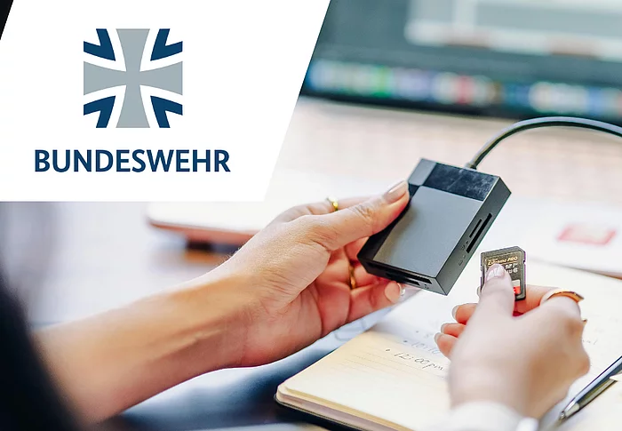 Symbolbild eines Datenträgerchips, der gerade in ein Lesegerät eingesteckt wird. Im Vordergrund ist das Logo der Bundeswehr zu sehen.