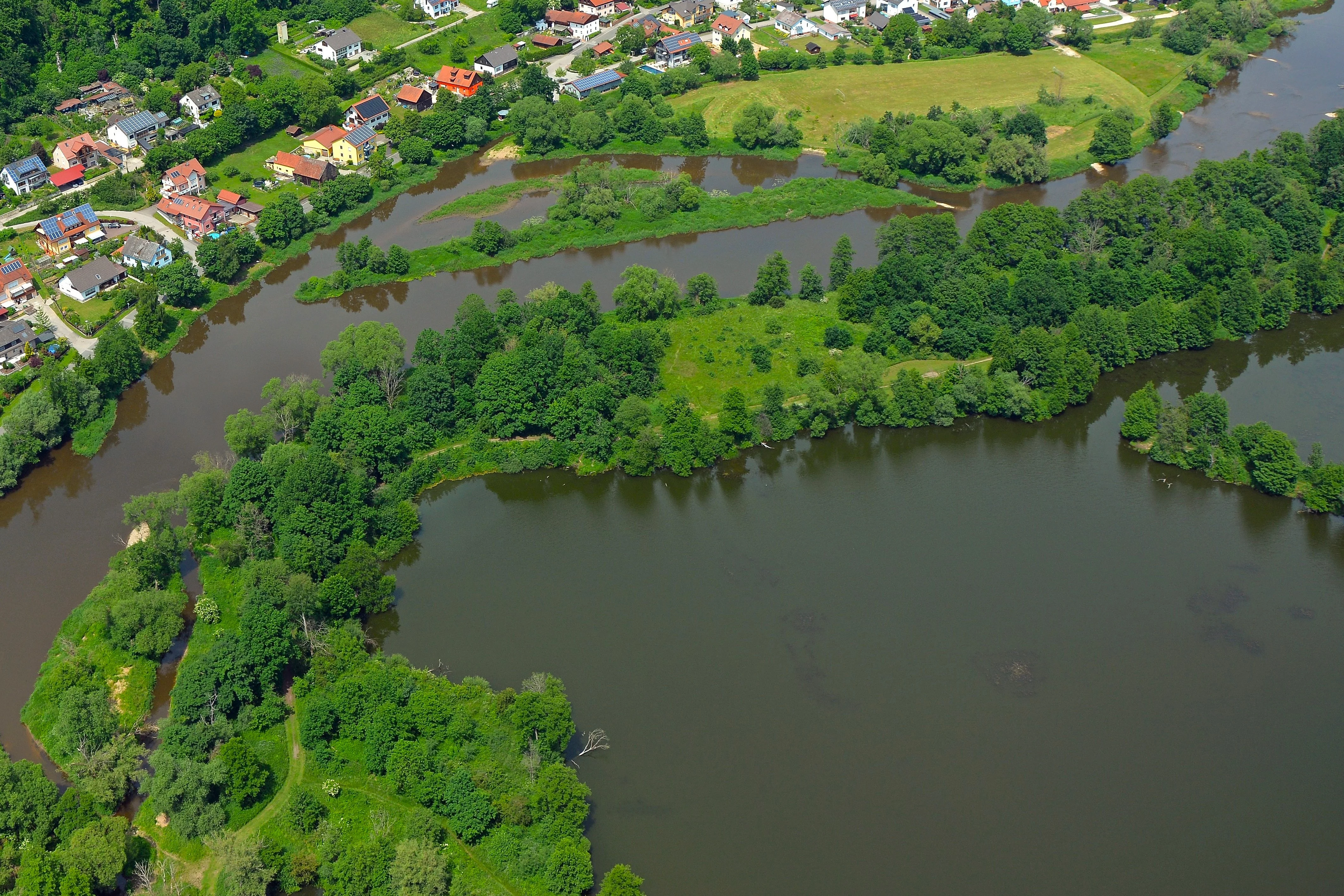 Blick auf den Saltendorfer Weiher und einen Abschnitt der Naab mit Wohnsiedlung im Hintergrund aus der Vogelperspektive.
