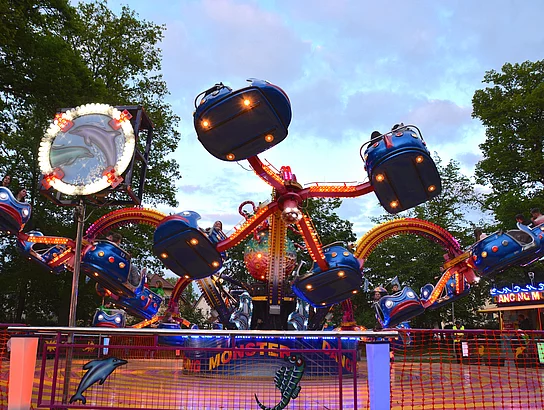 Das Rundfahrgeschäft "Kraken" bei Einbruch der Dunkelheit mit bunter Beleuchtung.