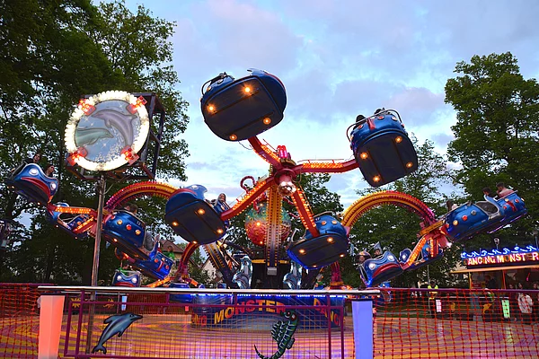 Das Rundfahrgeschäft "Kraken" bei Einbruch der Dunkelheit mit bunter Beleuchtung.