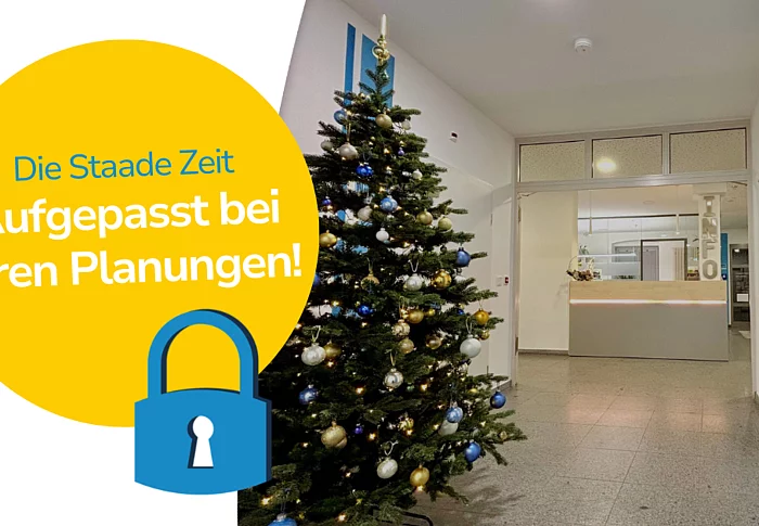 Das Bild zeigt einen festlich geschmückten Weihnachtsbaum im Foyer des Rathauses, ergänzt durch eine grafische Hinweistafel, die auf die besonderen Schließzeiten während der „Staaden Zeit“ aufmerksam macht.