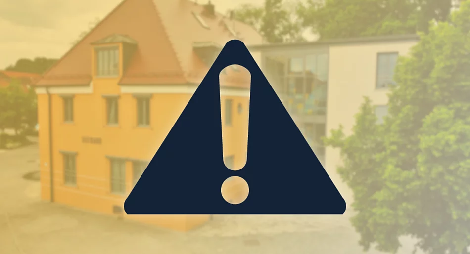 Auf einer gelblich verblassten Hintergrundaufnahme des Rathauses steht mittig ein großes, dunkelblaues Warnsymbol mit Ausrufezeichen.