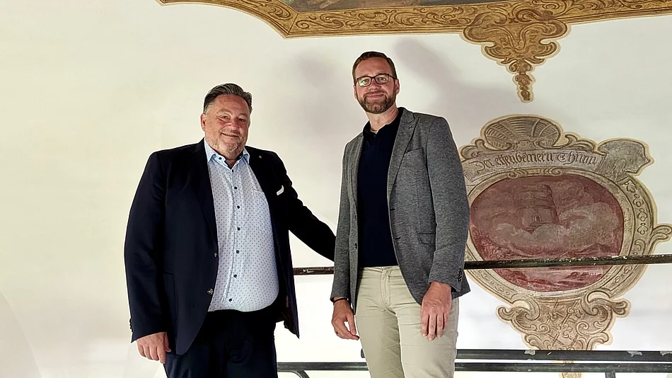 Bürgermeister Thomas Beer und Pfarrer Lucas Lobmeier stehen auf dem Arbeitsgerüst unmittelbar unter einem restaurierten Deckengemälde der Marien-Wallfahrtskirche Saltendorf. Im Hintergrund ist ein weiteres historisches Wandmotiv zu sehen.