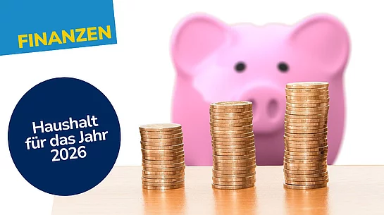 Grafik mit dem Titel „Finanzen – Haushalt für das Jahr 2026“, die drei steigende Münzstapel vor einem unscharfen Sparschwein zeigt.