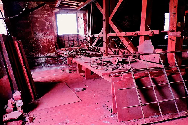 Rot leuchtende Innenräume durch vorhandenen Staub mit Blick auf die Poliertische im Obergeschoss.