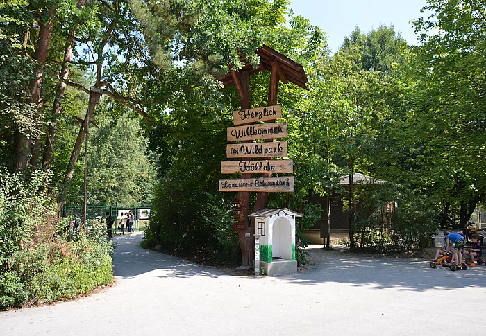 Ein aus alten Bäumen und aus Holz errichtete Willkommensschild begrüßt die Besucher des Wild- und Freizeitparks Höllohe.