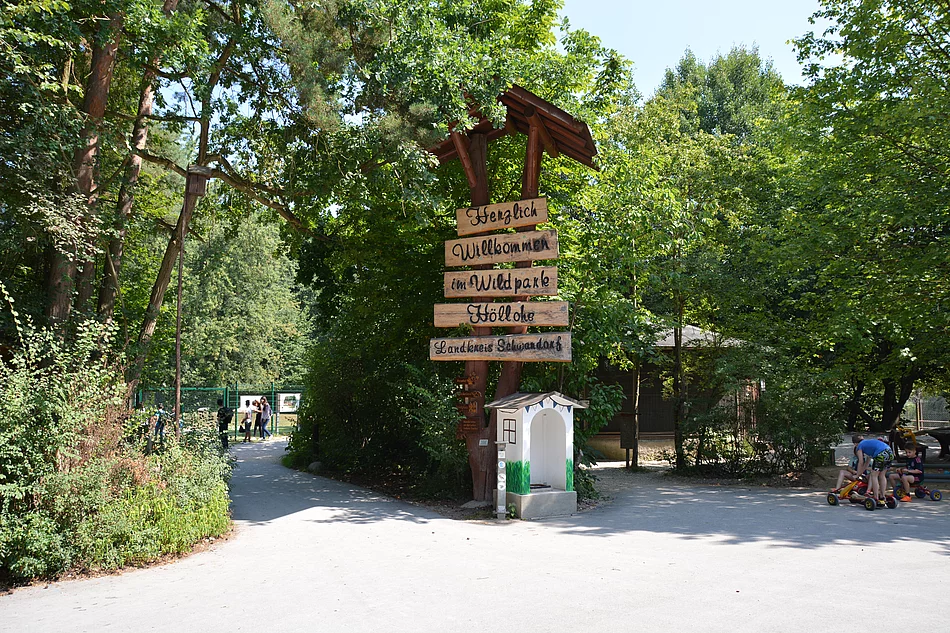 Ein aus alten Bäumen und aus Holz errichtete Willkommensschild begrüßt die Besucher des Wild- und Freizeitparks Höllohe.