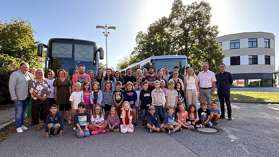 Gruppenfoto der künftigen Schulkinder mit Eltern und Begleitpersonen bei der Schnupperfahrt in Teublitz. Die Kinder stehen und sitzen im Vordergrund, dahinter sind zwei Busse zu sehen.