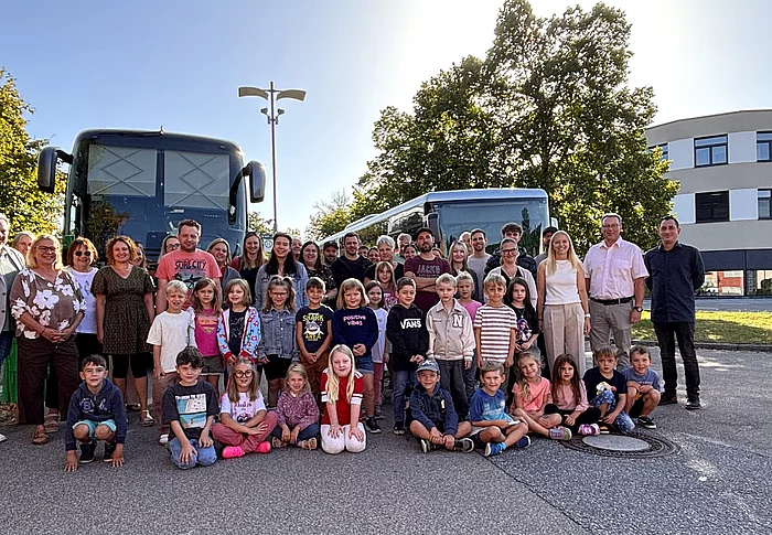 Gruppenfoto der künftigen Schulkinder mit Eltern und Begleitpersonen bei der Schnupperfahrt in Teublitz. Die Kinder stehen und sitzen im Vordergrund, dahinter sind zwei Busse zu sehen.