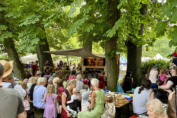 Viele Gäste mit Kindern lauschen dem Schauspiel der Puppenkiste.
