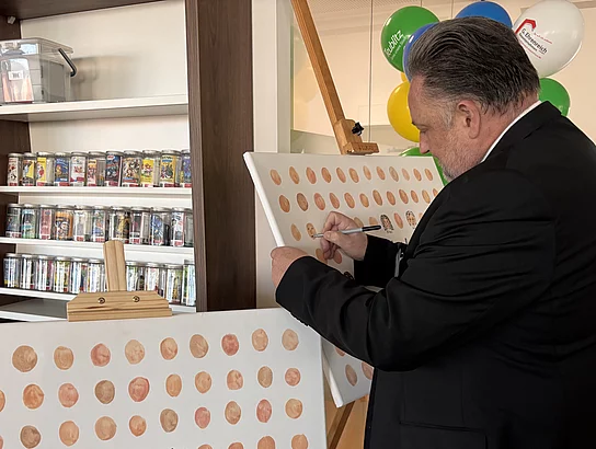 Der Bürgermeister verewigt sich symbolisch im Rahmen der Eröffnung.